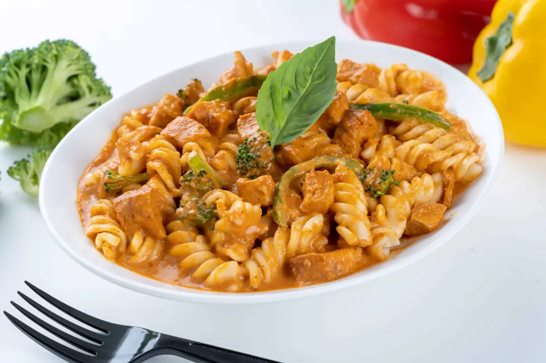 Pasta with red chicken pieces